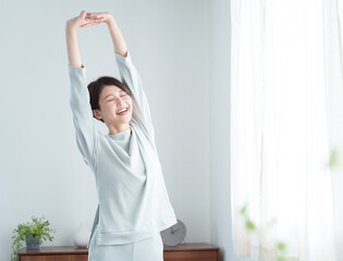 朝パジャマでストレッチする女性
