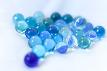 blue glass marbles on a white background close-up, macro photography