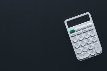 Calculator,money,mortgage,property concept.,Flat lay top view of white calculator over black background with copyspace suitable for business,financial,tax,mathematics,investment idea.