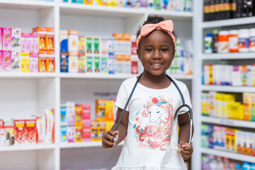 Portrait of Black African girl Child in a pharmacy with stethoscope, dreams to become doctor in future.