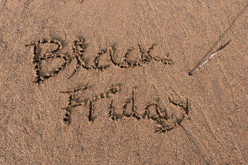 Black Friday text written in sand
