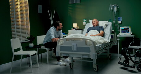 Son embraces his father in the hospital room, providing comfort during his recovery from a recent...