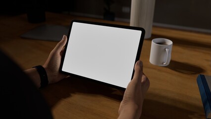 A person holding a tablet in a cozy home environment, perfect for mockups of apps related to productivity, digital media, or design tools