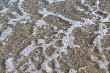 Shallow Sea Water with Bubbles on Sandy Shoreline