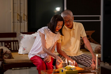 Senior asian couple is happily celebrating birthday together at home for love, relationship, bonding, longevity and marriage concept