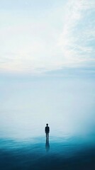 Solitary Figure Standing in a Serene, Foggy Water Body