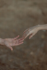A couple in love touches each other with their hands. Love story of a young couple in love. Wedding rings on ring fingers. Concept of a marriage proposal. Starting a family.