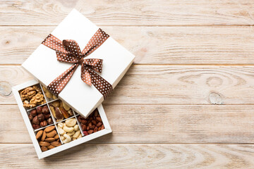 Various varieties of nuts lying in paper box on table background. Top view. Healthy food. Close up, copy space, top view, flat lay. Walnut, pistachios, almonds, hazelnuts and cashews