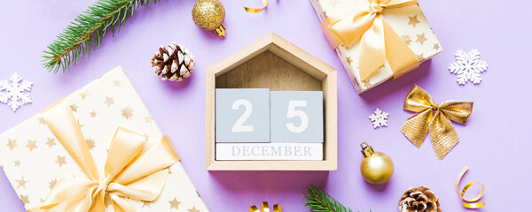 Christmas calendar 25 december. Christmas gift, fir branches, pine cones. Flat lay, top view. New Year decorations on a colored background