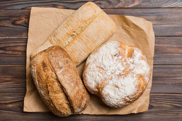 Assortment of freshly baked bread with napkin on rustic table top view. Healthy unleavened bread. French bread