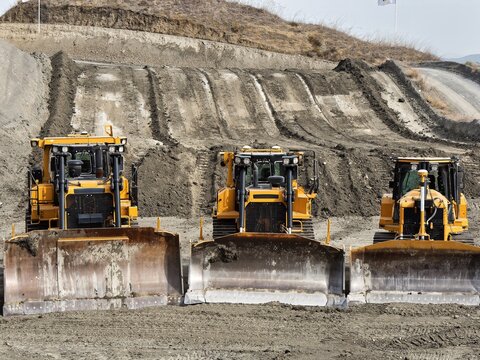 Yellow dozer parade of different sizes