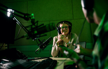 Male podcaster making podcast with young woman from his studio.