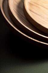 Wooden flat plates on a green background. The concept of ecological tableware. Products for modern kitchen. Zero emissions.