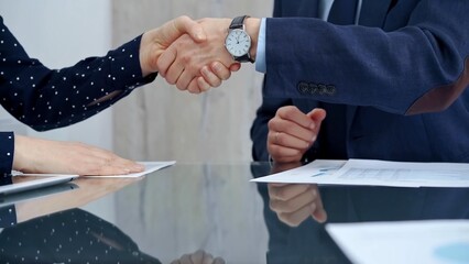 Obraz premium Professional handshake between two professionals and applauds at a corporate meeting with reflection on table over a business meeting. Business people concept
