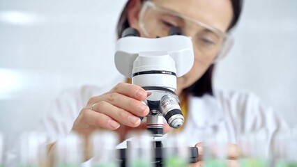 Woman scientist using microscope in laboratory. Microbiology science concept