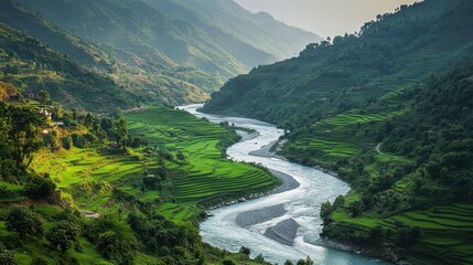 Detailed view of an Indian river winding through a lush green valley with terraced fields.