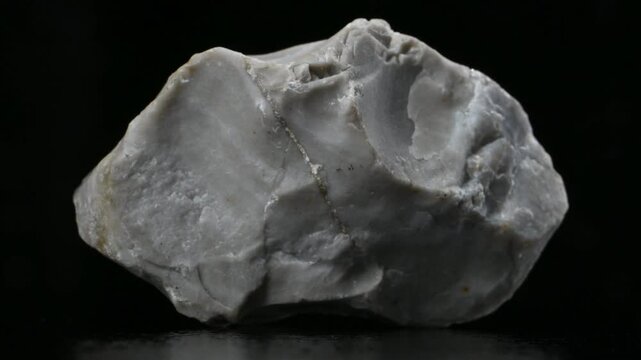 Flint (sedimentary cryptocrystalline form of 
 Quartz) sample rotating slowly against a black background [