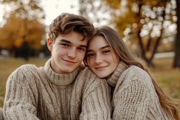 Fototapeta premium Young couple cuddling in sweaters, smiling together outdoors