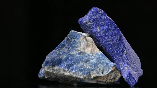 Lapis Lazuli - metamorphic semi-precious rock containing lazurite, pyrite and calcite - rotating slowly against a black background 