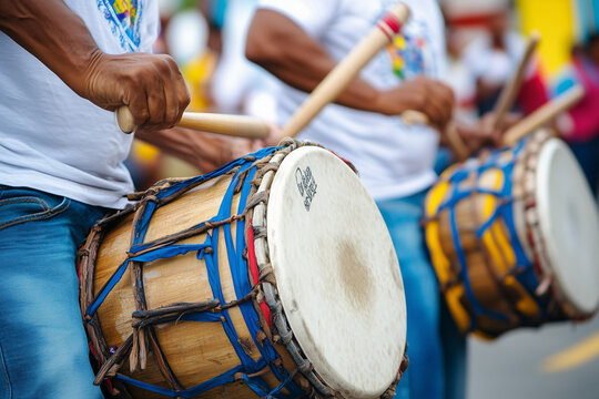Detalle de un tambor de madera en manos de m&uacute;sicos vestidos de blanco y azul, mientras la multitud disfruta de la m&uacute;sica en una animada fiesta patri&oacute;tica paname&ntilde;a.