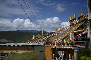 Explosion of colors and objects - the mixture of ShangRi-La architecture, prayer flags, red colors of the walls, blue sky and white structures