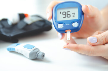 Woman is holding a blood glucose meter