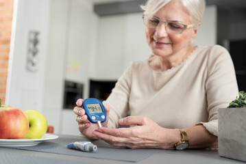 Woman using blood glucose meter, diabetes test