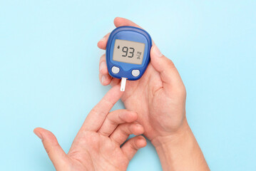 Person checking blood sugar level with glucometer