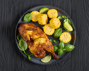 half of bbq chicken with corn cobs coins and basil