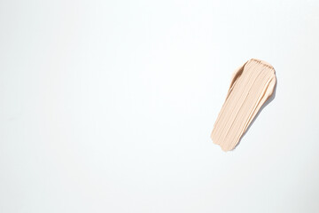 Liquid foundation smudge on white background. Beauty skincare texture swipe swatch. Cosmetic makeup cream sample isolated on white