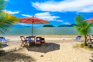 Jabaquara beach with umbrella and chairs in Paraty, Rio de Janeiro, Brazil. Paraty is a preserved Portuguese colonial and Brazilian Imperial municipality