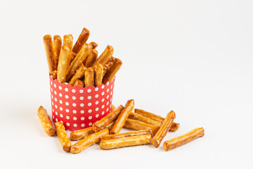 Red pack with salty mini breadsticks isolated on white background with copy space