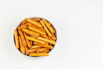 Top view of salty mini breadsticks on white blue plate isolated on white background with copy space