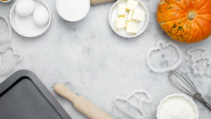 Ingredients for baking Halloween cookies including flour, butter, sugar, spices, eggs and pumpkin. Seasonal autumn baking