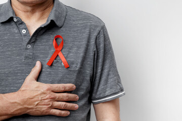 Man wears red AIDS awareness ribbon. World AIDS Day