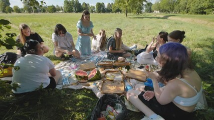 School children had a picnic under the tree with fruit and food.