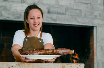 Smiling woman with a plate of lamb in her hands