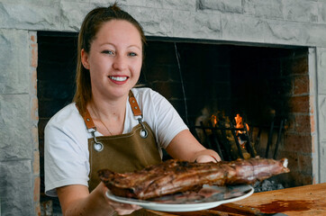 Smiling woman with a plate of lamb in her hands