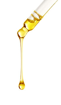 Essential oil dripping from pipette on white background
