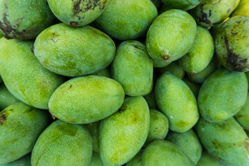 a pile of fresh mangoes is displayed.