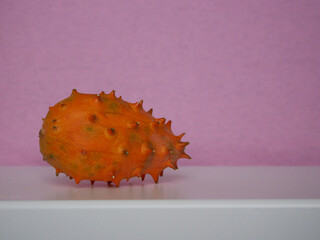 Kiwano Cucumis Metulifer tropical fruit close up at a pink background