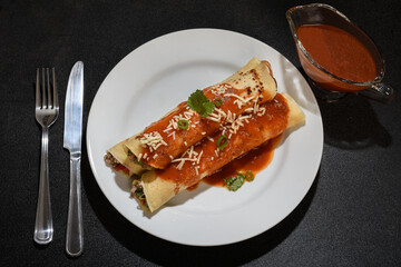  Meat pancake on a white plate with red sauce, dark background