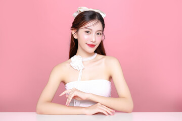 Pretty Asian woman model long hair perfect clear fresh skin smile on isolated pink background. Portrait elegant female beauty blogger make up artist in studio. Skincare, plastic surgery, spa concept.