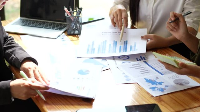 Business Meeting Analysis Professionals Collaborate on Charts and Graphs, Driving Teamwork and Strategy with Data Driven Documents.