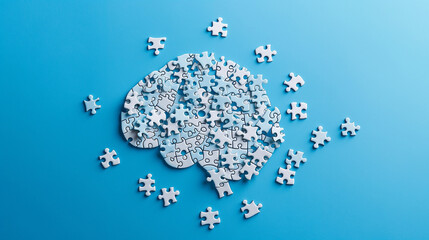 puzzle pieces arranged in the shape of human brain against a plain blue background, concept of brain storming critical thinking mental health 