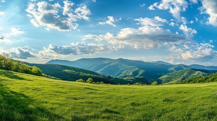 Obraz premium A panoramic view of lush green hills under a bright blue sky with scattered clouds.