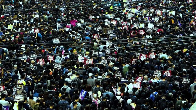 Hong Kong Social Protest - Crowd of Chinese people passing city streets at political demonstration - Top Angle Wide Long Panoramic View 4K
