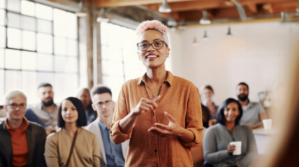 Confident woman speaking at a business meeting with diverse audience...