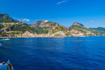 Amalfi, Italy. View of Amalfi and Amalfi Coast from the ferry. Seaside village with green mountains of Monti Lattari in Campania, Italy. Seascape from the sea on a sunny summer day on Amalfi, Atrani.