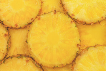 Pineapple juicy yellow slices as a background.